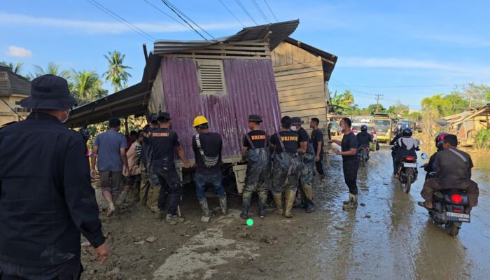 Bahu Membahu, Brimob Pindahkan Rumah Terseret Banjir yang Melintang di Jalan Nasional Tamiang–Langsa